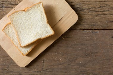 Kahvaltı ekmeğinin sabah güneşiyle birlikte ahşap bir masa üzerindeki görüntüsü ve kopyalama alanı