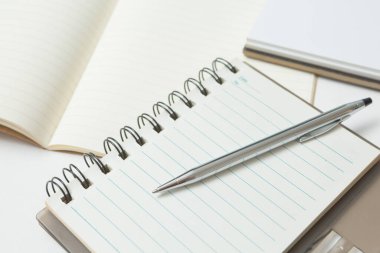 Pen 'in seçmeli odak noktası, beyaz arkaplan üzerine not defteri