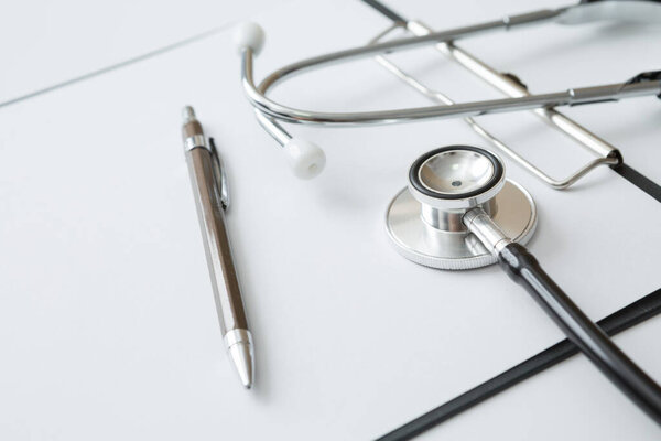 Stethoscope, Document Board, Notebook, Pen on white background and copy space
