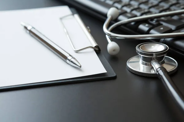 Stethoscope, Belge Tahtası, Klavye Bilgisayarı, Not Defteri, Siyah arkaplan üzerine Kalem ve Boşluğu Kopyala