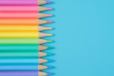 Mavi arkaplanda Pastel renkli kalemlerin renkli deseni ve boşluğu kopyala