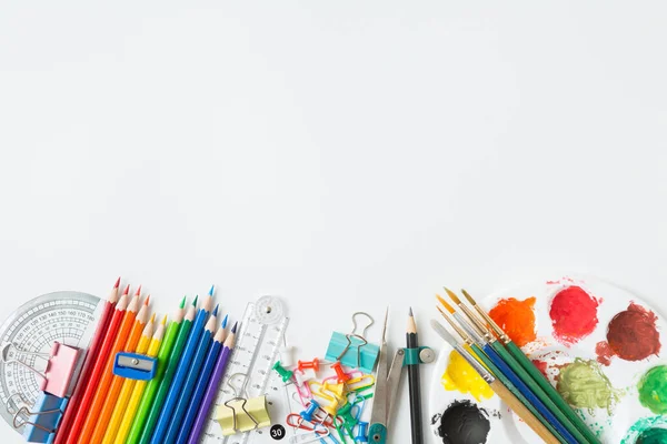 Renkli Suluboya paleti, boya fırçası, renkli kalemler, cetvel ve çizim ekipmanlarının beyaz arkaplanda üst görünümü ve boşluk kopyala