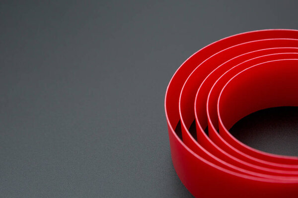 Spiral red ribbon on a black background and copy space