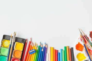 Renkli Suluboya paleti, boya fırçası, renkli kalemler, cetvel ve çizim ekipmanlarının beyaz arkaplanda üst görünümü ve boşluk kopyala