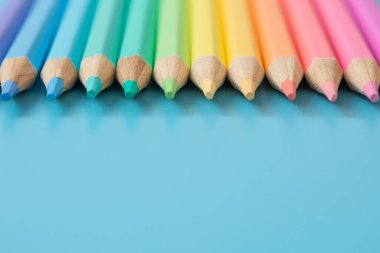 Mavi arkaplanda Pastel renkli kalemlerin renkli deseni ve boşluğu kopyala