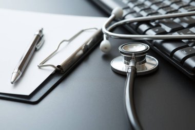 Stethoscope, Belge Tahtası, Klavye Bilgisayarı, Not Defteri, Siyah arkaplan üzerine Kalem ve Boşluğu Kopyala