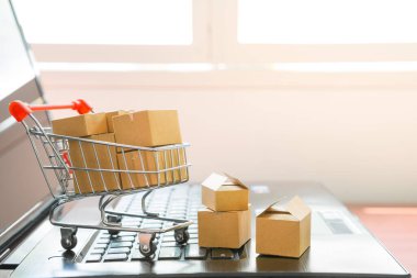 Online alışveriş konsepti için dizüstü bilgisayardaki alışveriş arabasında bir sürü paket var.