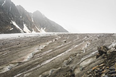 Aktru buzulu. Erimiş buzlu soğuk su buzulun eğimi boyunca kavisli bir yataktan aşağı akar. Tırmanması zor güzel manzarası, Altay kara doğası ile turistik bir gezi keskin dağlar. 