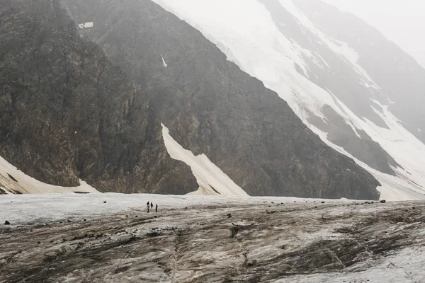 Buzulun eteklerinde alpenists vardır. Altay karlı dağların güzel doğası tonda fotoğraf. Küçük insanlar. Aktru Buzulu. Altay Dağı. Sibirya. Rusya.