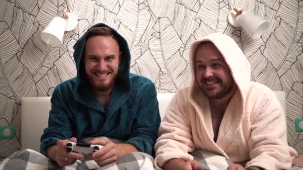 Image: https://st4.depositphotos.com/26597264/28715/v/600/depositphotos_287155136-stock-video-two-guys-play-computer-games.jpg Two guys play computer games on the bed in bathrobes and win Slow motion footage 2 bearded men play video game Video by VetalVit Stock Footage 287155136