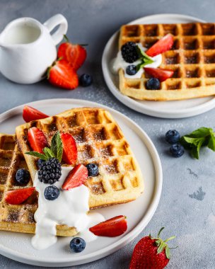 Ekşi krema, çilek, yaban mersini ve böğürtlen ile Brüksel waffle