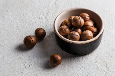 Beyaz arka plan üzerinde bir kase macadamia fındık