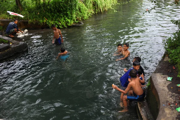 Yogyakarta, Endonezya - 28 Mayıs 2020: Çocuklar çok eğlenceli bir nehirde su oynayıp yüzüyorlar