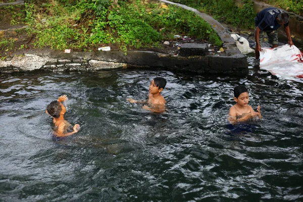 Yogyakarta, Endonezya - 28 Mayıs 2020: Çocuklar çok eğlenceli bir nehirde su oynayıp yüzüyorlar