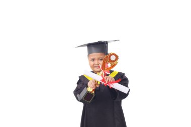 Asyalı bir anaokulu çocuğunun portresi. Basit ve ev yapımı mezuniyet kıyafetleri giydiği için mutlu ve heyecanlı.