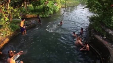 Yogyakarta, Endonezya - 8 Haziran 2020: Çocuklar çok eğlenceli bir nehirde su oynayıp yüzüyor