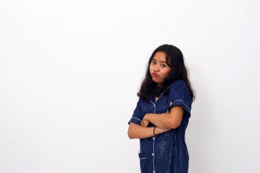 Mavi bir gecelik ya da pijama giymiş Asyalı bir kadının portresi ayakta duruyor ve elleri katlanmış olarak mutlu oluyor. Beyaz arkaplanda izole