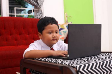 İnternette bilgisayar kullanan Asyalı bir öğrenci.