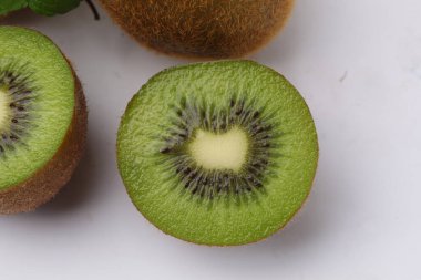 Kivi meyvesini kapat ve beyaz arka planda izole edilmiş kivi dilimini kes