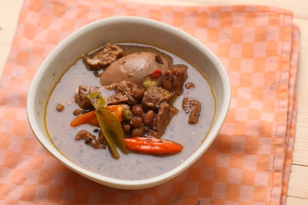 Brongkos. Javanese traditional food of indonesia. made from tofu, beef, and other ingredients. in white bowl.