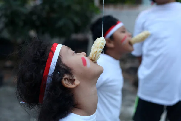 インドネシアの子供たちはインドネシアの独立記念日を祝うためにクラッカー競争を食べています — ストック写真