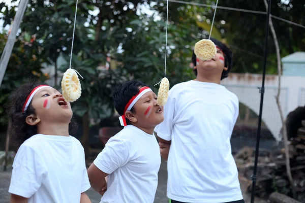 インドネシアの子供たちはインドネシアの独立記念日を祝うためにクラッカー競争を食べています — ストック写真