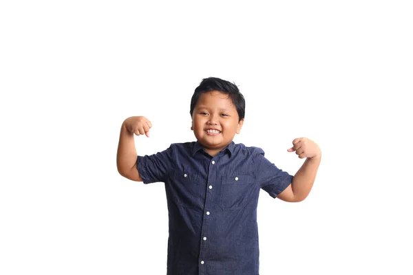 青で愛らしいアジアの少年は彼の手を持ち上げながら立っていると彼の腕の筋肉のジェスチャーを示していますコピースペースと白の背景に隔離 — ストック写真