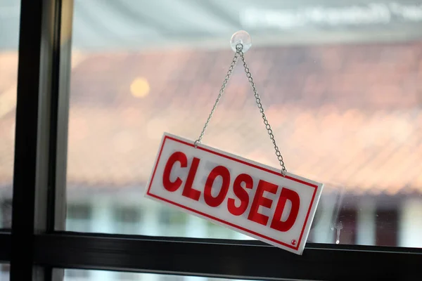 Close up of closed sign hanging on shop door