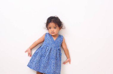 Beyaz arka planda tek başına dikilirken kıvırcık saçlı Asyalı güzel kızın yan görünüşü