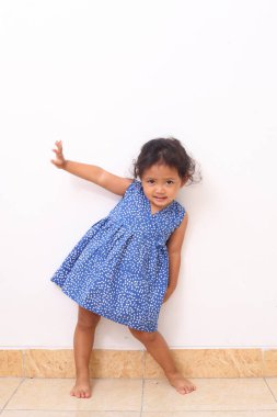 Beyaz arka planda tek başına dikilirken kıvırcık saçlı Asyalı güzel kızın yan görünüşü