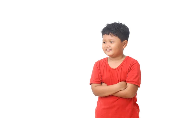 白い空間を眺めながら 赤いシャツを着たアジア系の少年が立って笑っている 白地に隔離された — ストック写真