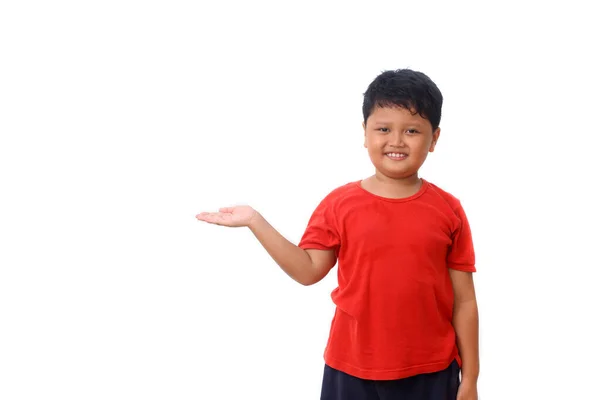 身穿红衫的亚洲男孩站在那里 展示一些东西 在白色背景上与版权保护隔离 — 图库照片