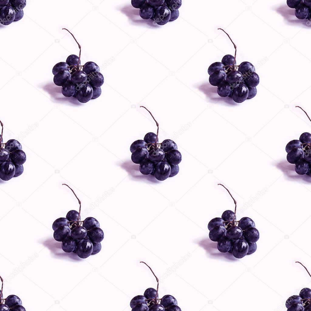 Trendy seamless pattern with small bunch of black round grapes with shadow on blank white. Photographic collage. Creative background. Natural organic fruit. Healthy, Sweet and tasty food. Violet tone.