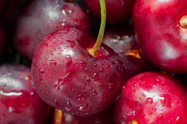 Böğürtlenlerin arka planında su damlaları olan olgun parlak kiraz. Tatlı, tart ve turta için taze malzeme. Vitamin dolu. Organik tarım, yatay makro çekim.