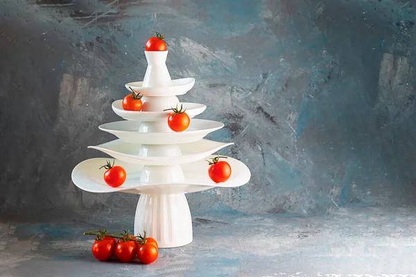 Beyaz tabak piramidi, kırmızı domateslerle süslenmiş ve aşağıda koyu renk kreatif konsept, bulaşık takımı, sebze, sebze, mutfak, restoran, kartpostal, Noel, Yeni Yıl