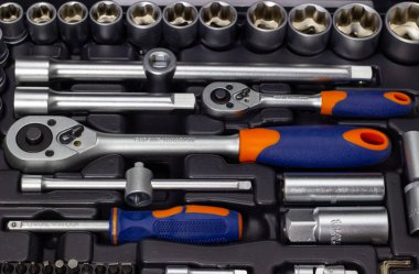 Koyu bir arka plan üzerinde siyah bir kasada bir takım araçlar.