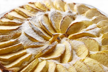 Beyaz bir arka plan üzerinde pudra şekeri ile toz ev yapımı elmalı turta