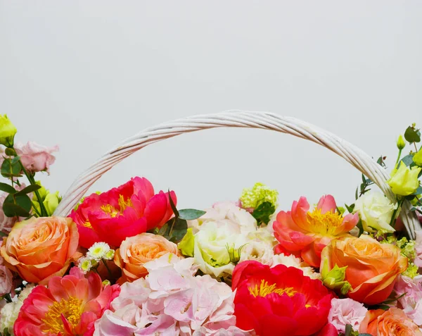 Kompozycja z jasnymi kolorami piwonii, Lisianthus, róże w białym koszyku — Zdjęcie stockowe