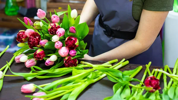 florist girl makes a bouquet of tulips