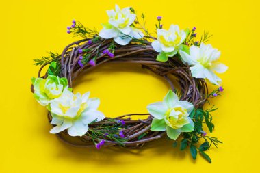 sarı bir arka plan üzerinde nergis ile dekore çelenk