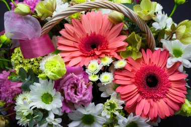 hasır sepette koyu bir arka plan çiçekler üzerinde beyaz bir sepet içinde parlak çiçek düzenleme