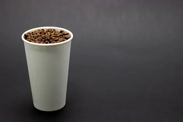 Κόκκους καφέ σε ένα ποτήρι σε σκοτεινό σημείο φόντου για κείμενο — Φωτογραφία Αρχείου
