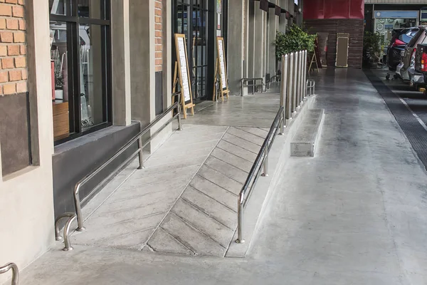 Alışveriş merkezinin girişinde engelliler için bir rampa var..