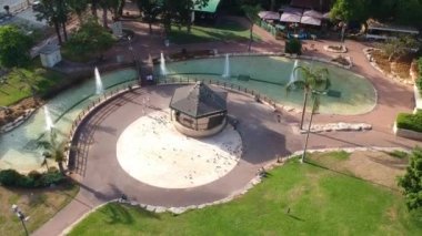 Ebeveynler bir çardak ve çeşmeler ile güzel bir parkta çocuklarla yürümek