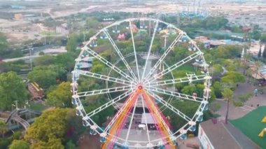 Dönme dolap. Güzel bir eğlence parkının arka planında gözlem çarkının yanında uçan bir drone güzel bir görünüm.