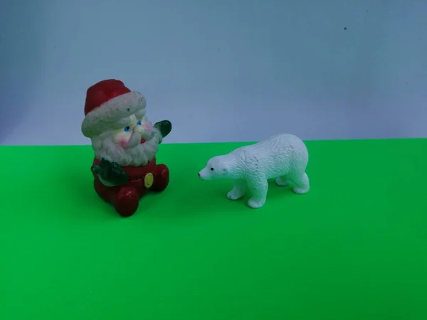 本物の自然なショットによって撮影された白と薄緑色の背景に北極熊とおもちゃのクリスマス陽気サンタクロース — ストック写真