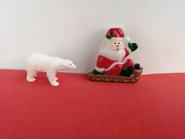 サンタクロースとホッキョクグマの陽気な挨拶は 本当の自然なクローズアップショットによって撮影された赤と白の背景の後ろに — ストック写真
