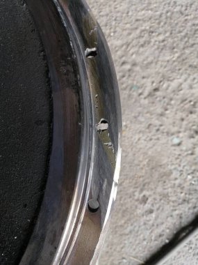 sol tarafta gri bir beton zemin arka planda delikler ile yuvarlak bir yapısal metal yüzeyin güzel arka plan ve doku parçası