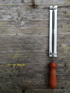 gerçek bir doğal yakın çekim çekim ile sağ yüzeyçekim üzerinde gri ahşap arka plan üzerinde elektrikli testere zinciri keskinleştirmek için yeni temiz dosya