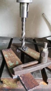 gerçek bir closeup çekilen metal bir yüzey üzerinde büyük bir matkap ile demir bir plaka delme